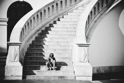 Girl tying shoelace while sitting on steps
