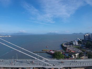 High angle view of cityscape by sea against sky