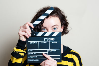 Portrait of woman with movie clapperboard