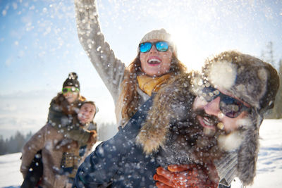 Friends enjoying during snowfall