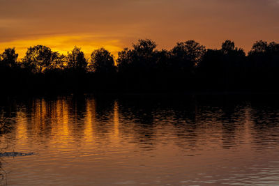 Scenic view of lake against orange sky