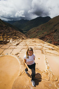 Young woman is walking near the famous salt mines in peru