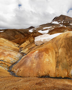 Landscape in ocher and brown tones with snowfields and a small river, iceland, kerlingarfjöll area