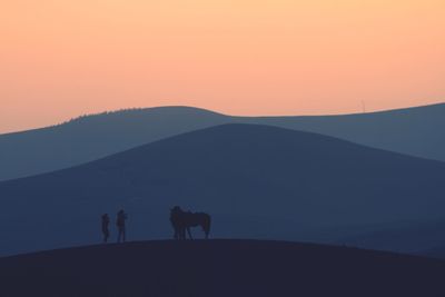 Men standing on silhouette landscape