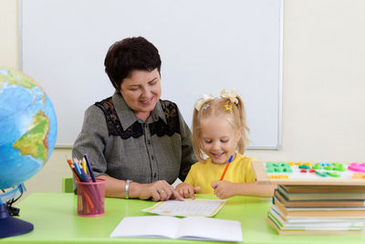 Portrait of smiling girl playing with toy on table