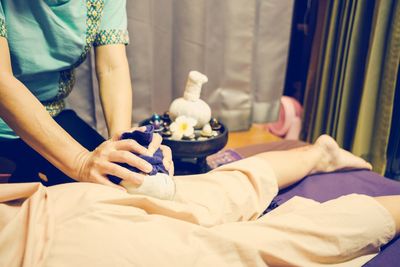 Midsection of woman massaging customer on bed