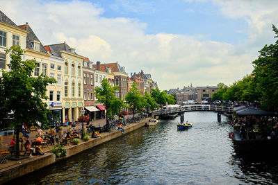 Bridge over canal in city against sky