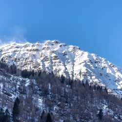 Scenic view of snowcapped mountains against blue sky