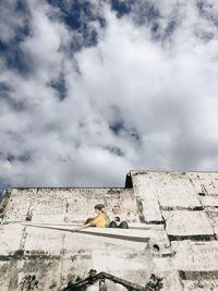 Low angle view of built structure against cloudy sky