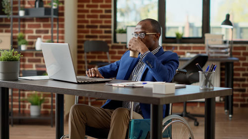 Young man using laptop at cafe