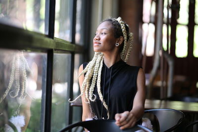 Young woman looking away while sitting at cafe