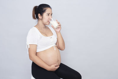 Young woman standing against white background