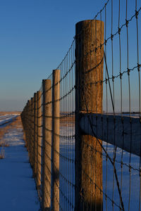 Low angle view of fence against sky