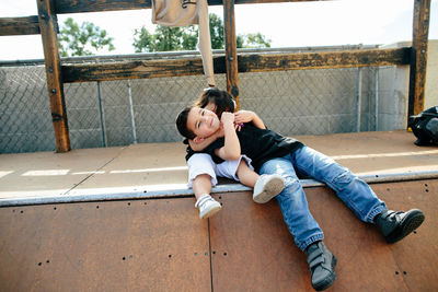 Little girl strangle holds brother on half pipe