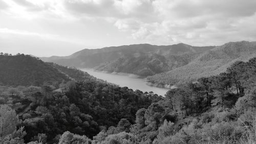 Scenic view of river against cloudy sky