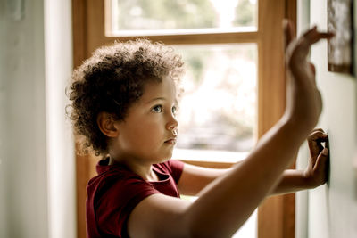 Curious boy using home automation on wall