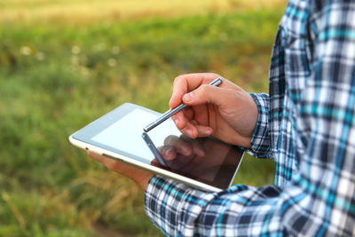 Midsection of man using mobile phone