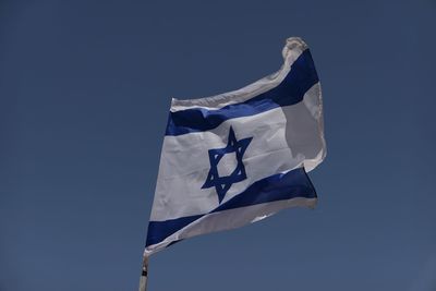 Low angle view of israeli flag against clear blue sky