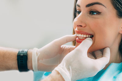 Cropped image of dentist touching patient teeth