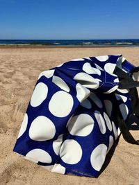 Close-up of umbrella on beach against sky