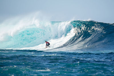 Man surfing in sea against sky