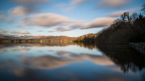 Scenic view of lake by trees against sky