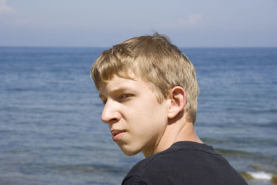 Portrait of young man against sea against sky