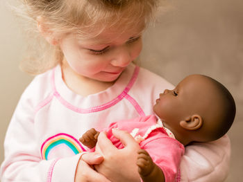 Close-up of cute girl playing with doll