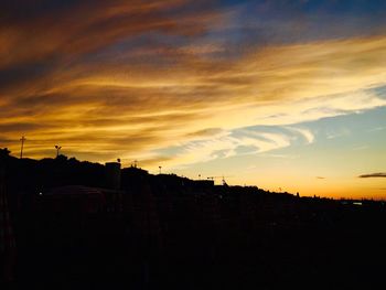 Silhouette of buildings against sky at sunset