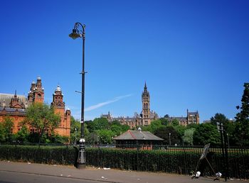 Street amidst buildings against clear blue sky