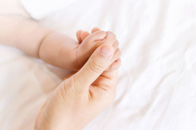 Close-up of woman hand on bed