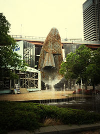 Fountain in city against clear sky