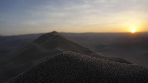 Scenic view of desert against sky during sunset