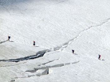 High angle view of people hiking on snowcapped mountain