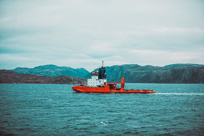 Fishing boat in sea against sky