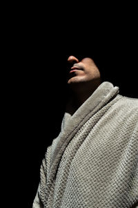 Man wearing bathrobe standing in darkroom