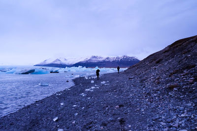 Tourists on snow covered mountain