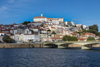 View of buildings and river against blue sky