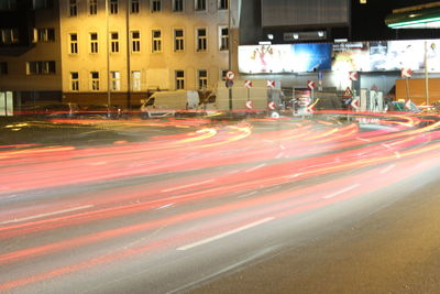 Light trails on city street by buildings at night