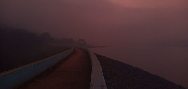 Empty road against sky during foggy weather