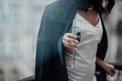 Midsection of woman drinking glass