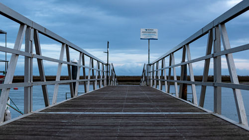 Empty footbridge against sky