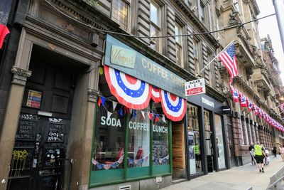 Low angle view of sign on street against buildings in city