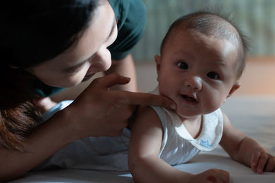 Mother playing with cute girl at home