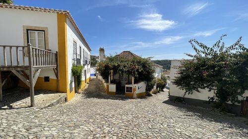 Footpath amidst buildings against sky