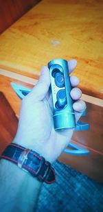 Close-up of hand holding camera on table