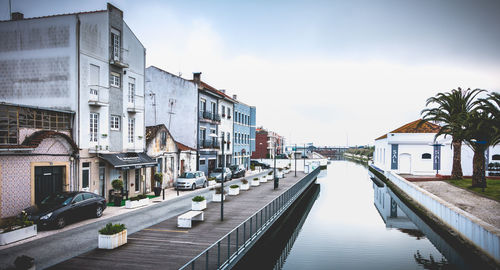 Canal amidst buildings in town against sky