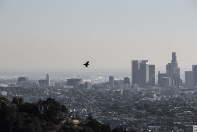 Silhouette cityscape against clear sky