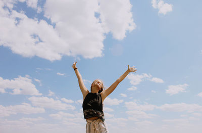 Low angle view of woman standing against sky