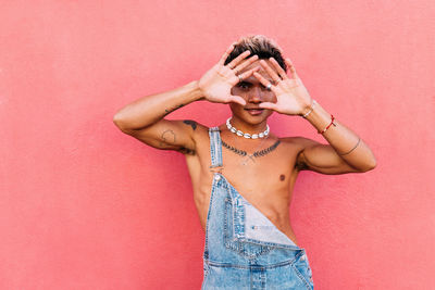 Portrait of gay man against wall